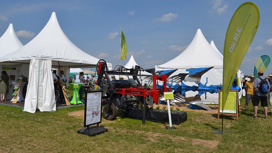 Zelt der Innovationsförderung neben Exponaten auf den Öko-Feldtagen © BLE