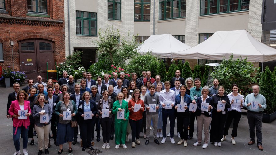 Ein Gruppenbild aller Teilnehmenden, die den Schriftzug "RePack-Netzwerk" hochhalten 