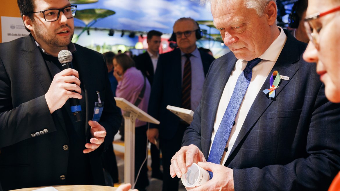 Max Sturm (HS Albstadt-Sigmaringen) erläutert Bundeslandwirtschaftsminister Rainer und Präsidentin Margareta Büning-Fesel (BLE) die innovative Lebensmittelverpackung